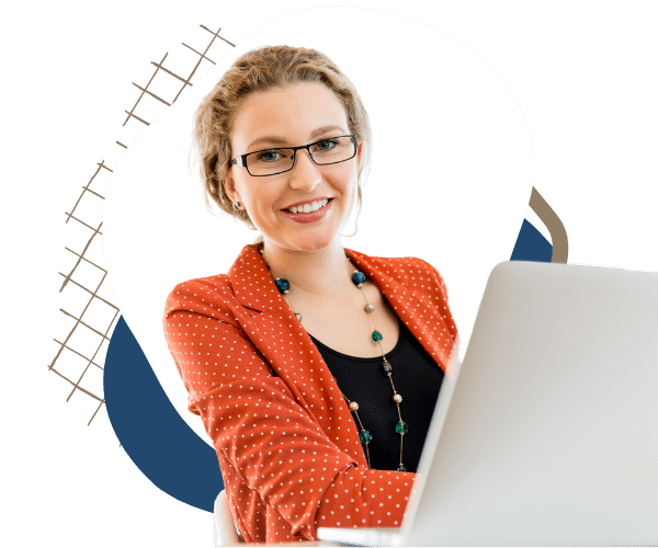 Blond woman with glasses smiling and sitting in front of the laptop in the office